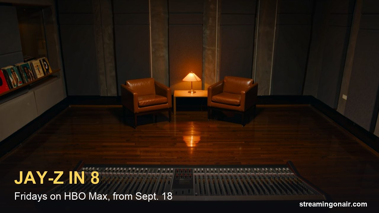 A dim recording studio control room at night with a vintage mixing console and two empty leather chairs